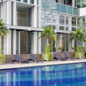 Hotel pool with pool chairs at Fraser Residence Sudirman Jakarta.