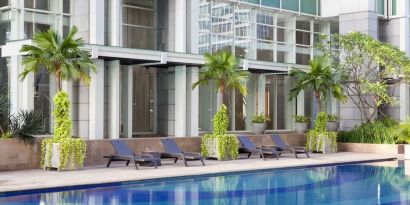 Hotel pool with pool chairs at Fraser Residence Sudirman Jakarta.