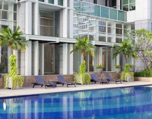 Hotel pool with pool chairs at Fraser Residence Sudirman Jakarta.