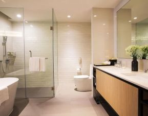 Guest bathroom with bath and shower at Modena By Fraser Bangkok.