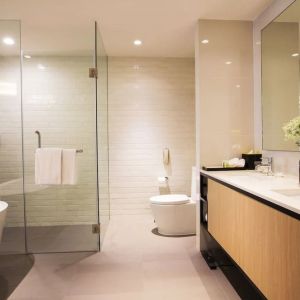 Guest bathroom with bath and shower at Modena By Fraser Bangkok.