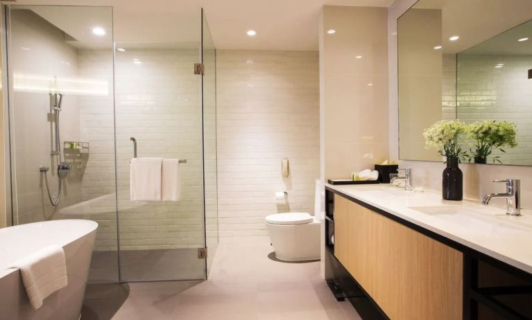 Guest bathroom with bath and shower at Modena By Fraser Bangkok.