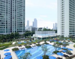 Outdoor pool with lounge chairs at Fraser Place Setiabudi Jakarta.