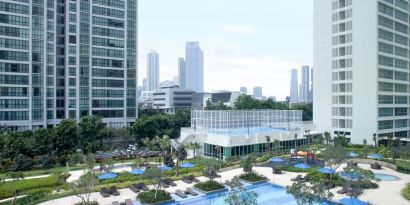 Outdoor pool with lounge chairs at Fraser Place Setiabudi Jakarta.