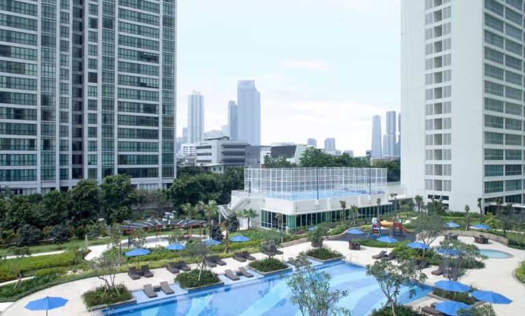 Outdoor pool with lounge chairs at Fraser Place Setiabudi Jakarta.