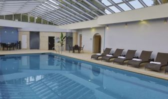 Indoor pool with seating area at DoubleTree By Hilton Oxford Belfry.