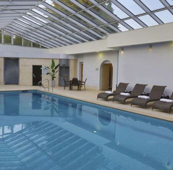 Indoor pool with seating area at DoubleTree By Hilton Oxford Belfry.