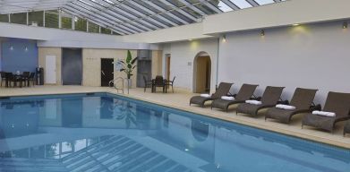 Indoor pool with seating area at DoubleTree By Hilton Oxford Belfry.