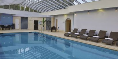 Indoor pool with seating area at DoubleTree By Hilton Oxford Belfry.