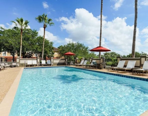 Outdoor pool with palm trees at Hyatt Place Orlando I-Drive.