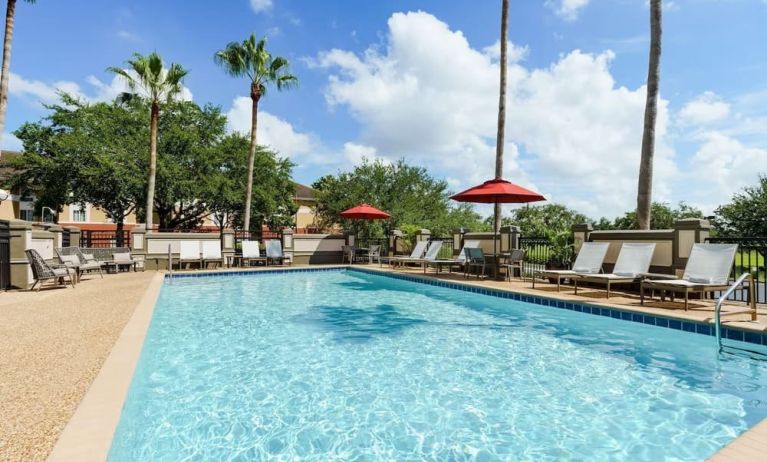 Outdoor pool with palm trees at Hyatt Place Orlando I-Drive.