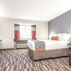 Spacious king room with TV at Coratel Inn & Suites By Jasper Rochester.