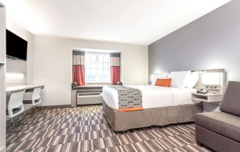 Spacious king room with TV at Coratel Inn & Suites By Jasper Rochester.