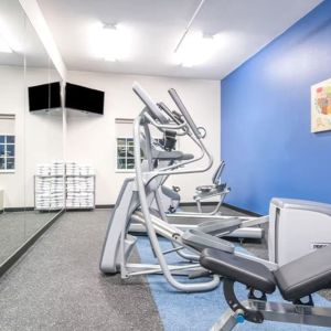 Fitness center at Coratel Inn & Suites By Jasper Rochester.