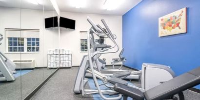 Fitness center at Coratel Inn & Suites By Jasper Rochester.