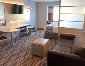 King suite with lounge area at Coratel Inn & Suites By Jasper Rochester.