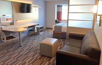 King suite with lounge area at Coratel Inn & Suites By Jasper Rochester.