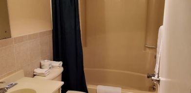 Guest bathroom with shower at Bay Breeze Motel.