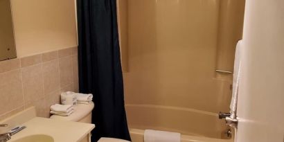 Guest bathroom with shower at Bay Breeze Motel.