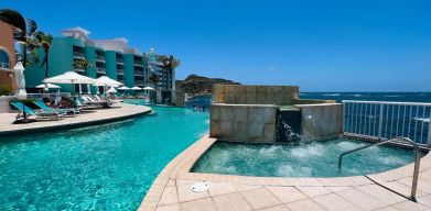 Glistening pool during daytime alongside jacuzzi hot tub at Oyster Bay Resort in St. Maarten.