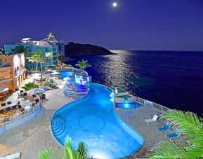 Aerial nighttime angle of lit up Infinity Pool at Oyster Bay Resort in St. Maarten.