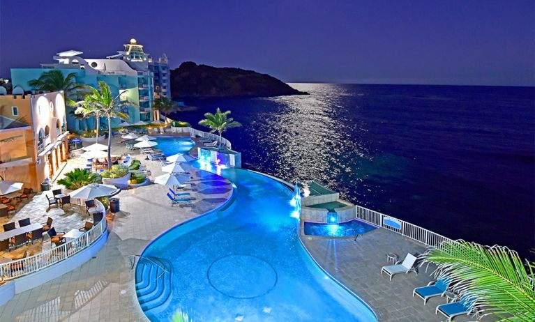 Aerial nighttime angle of lit up Infinity Pool at Oyster Bay Resort in St. Maarten.