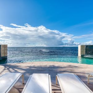 Chair deck relaxing view of Infinity Pool and Oyster Bay, at Oyster Bay Resort in St. Maarten. 