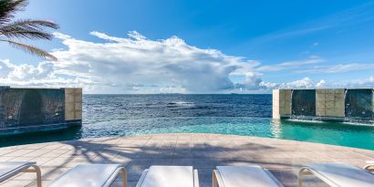 Chair deck relaxing view of Infinity Pool and Oyster Bay, at Oyster Bay Resort in St. Maarten. 