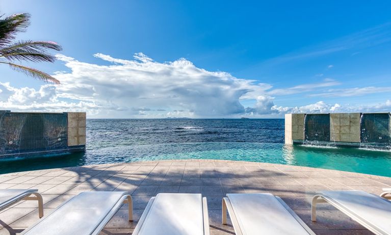 Chair deck relaxing view of Infinity Pool and Oyster Bay, at Oyster Bay Resort in St. Maarten. 