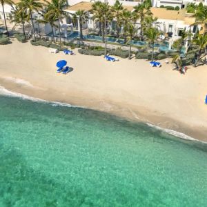 Oyster Bay Resort's beach with sun tanning chairs and waves going on shore. 