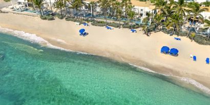 Oyster Bay Resort's beach with sun tanning chairs and waves going on shore. 