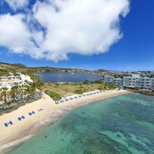 Oyster Bay Resort in St. Martin with beach chairs lined along beach. 