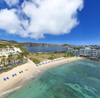 Oyster Bay Resort in St. Martin with beach chairs lined along beach. 