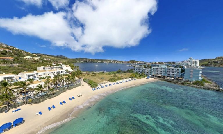 Oyster Bay Resort in St. Martin with beach chairs lined along beach. 