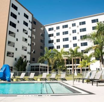 Hotel pool with loungers at Element Miami Doral.