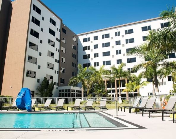 Hotel pool with loungers at Element Miami Doral.