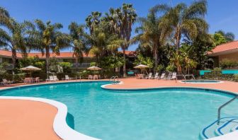 Outdoor pool with palm trees at Uptown Oasis San Jose Airport.