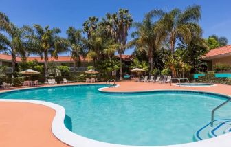 Outdoor pool with palm trees at Uptown Oasis San Jose Airport.