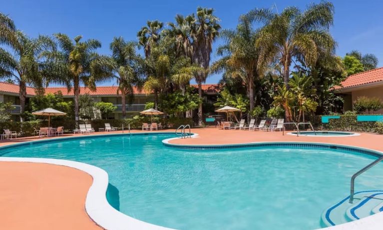 Outdoor pool with palm trees at Uptown Oasis San Jose Airport.