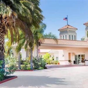 Parking and hotel exterior at Uptown Oasis San Jose Airport.