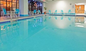 Indoor pool with seating area at Laguardia Plaza Hotel.