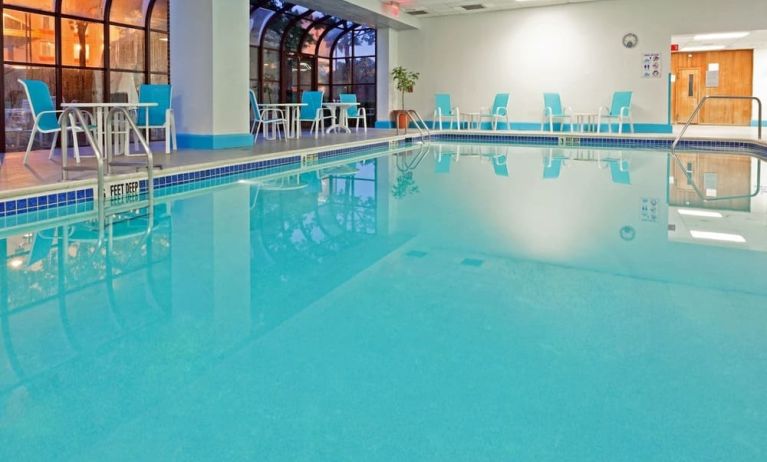 Indoor pool with seating area at Laguardia Plaza Hotel.