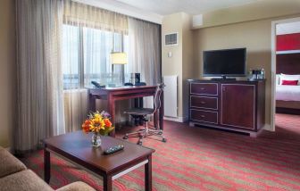 Spacious king room with lounge area at Laguardia Plaza Hotel.