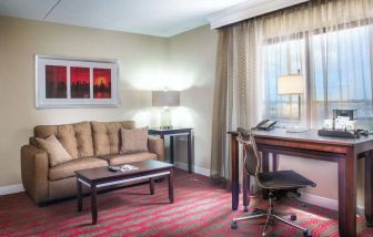 King room with lounge and work desk at Laguardia Plaza Hotel.