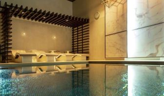 Indoor pool with chair loungers at Hilton Aberdeen TECA.