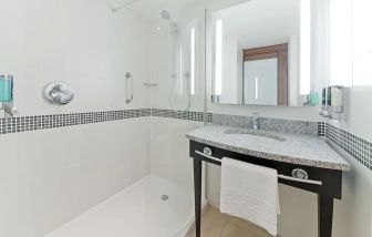 Guest bathroom with shower at Hampton By Hilton London Gatwick Airport.