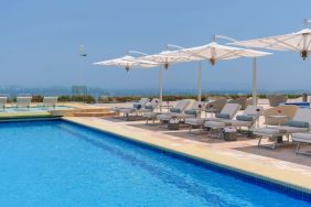 Outdoor pool with pool loungers at Grand Miramar All Luxury Suites & Residences.