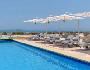 Outdoor pool with pool loungers at Grand Miramar All Luxury Suites & Residences.