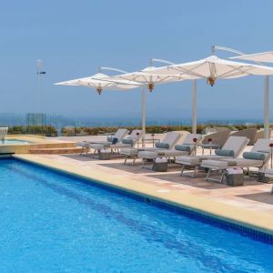 Outdoor pool with pool loungers at Grand Miramar All Luxury Suites & Residences.