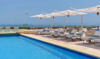 Outdoor pool with pool loungers at Grand Miramar All Luxury Suites & Residences.